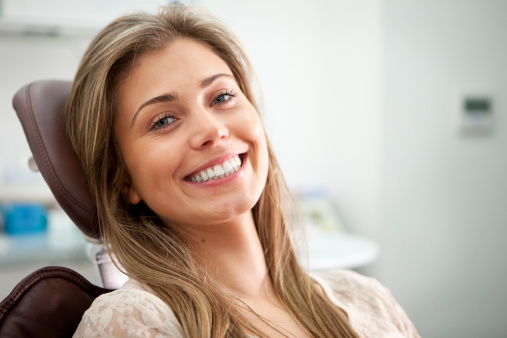 Woman smiling in dental chair atUptown Family Dental in Portland, OR