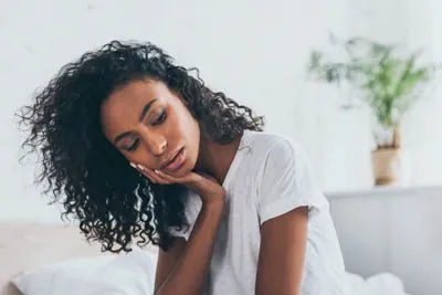 woman holding her mouth from tooth pain