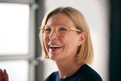 woman smiling big after dental implants helped restore her smile