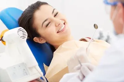 woman smiling during her dental cleaning at Uptown Family Dental